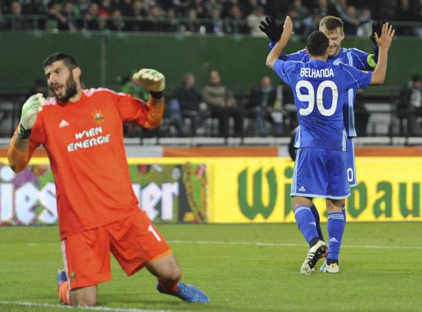Ein Torwart kniet enttäuscht, während zwei Fußballspieler jubeln.