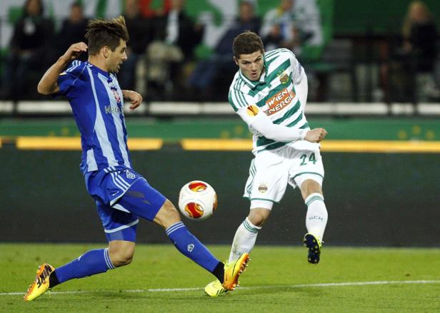 Zwei Fußballspieler kämpfen um den Ball während eines Spiels.