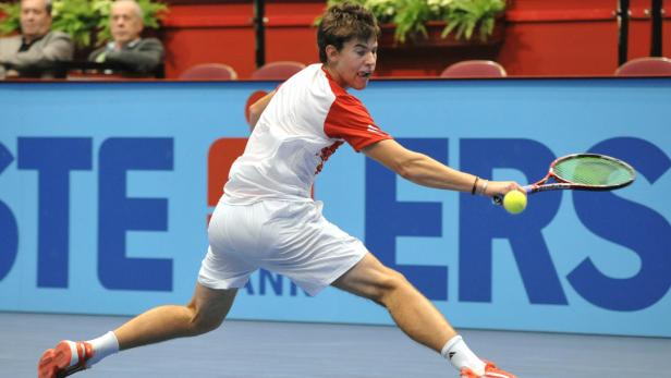 Ein Tennisspieler schlägt einen Ball während eines Matches.