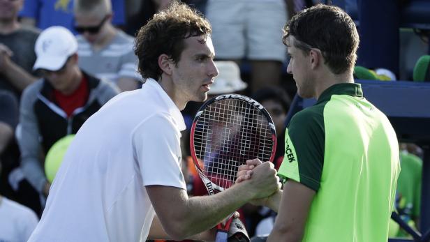 Zwei Tennisspieler schütteln sich nach einem Match die Hände.