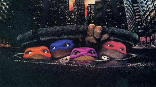 Die Teenage Mutant Ninja Turtles schauen aus einem Gullydeckel in einer nächtlichen Stadt.