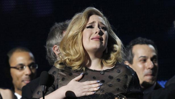 Adele mit Tränen in den Augen, die Hand auf ihr Herz gelegt hat.