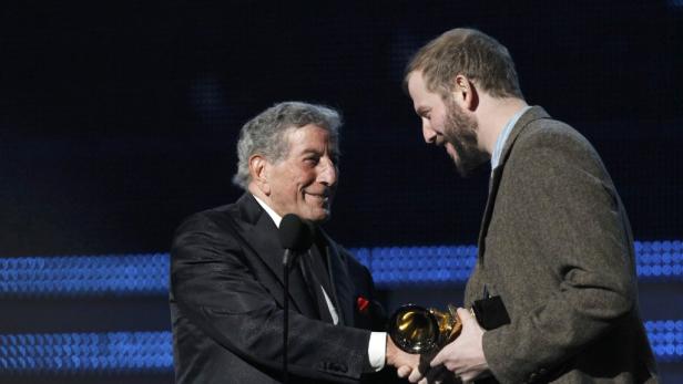 Tony Bennett schüttelt einem Mann die Hand und nimmt eine Auszeichnung entgegen.