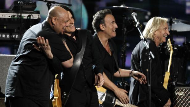 Bruce Springsteen und die E Street Band treten gemeinsam auf der Bühne auf.