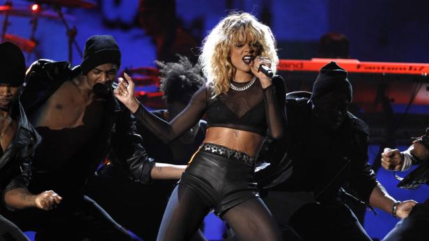 Rihanna tritt mit Tänzern auf einer Bühne auf.