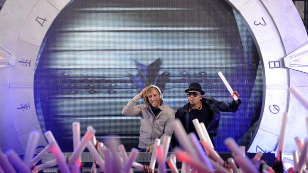 David Guetta und Chris Brown treten vor einer großen LED-Wand auf.