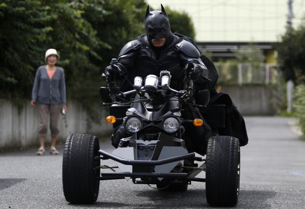 Batman fährt ein Quad auf einer Straße entlang.