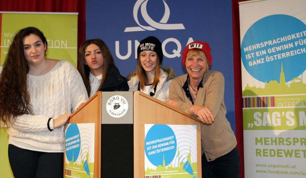 Vier Frauen stehen hinter einem Rednerpult mit dem Logo von „SAG’S multi!“.