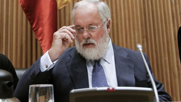 Umweltminister Cañete Ein Mann mit Bart und Brille sitzt an einem Tisch mit einem Mikrofon.