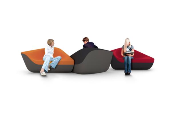 Drei Personen sitzen auf modularen Sofas in Orange, Grau und Rot.