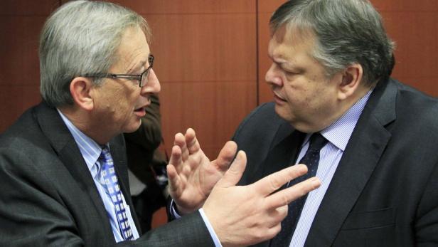 Jean-Claude Juncker gestikuliert während eines Gesprächs mit einem anderen Mann.