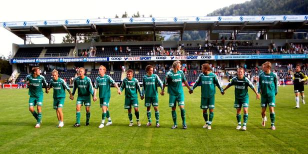 Eine Fußballmannschaft hält Händchen vor einem Spiel.