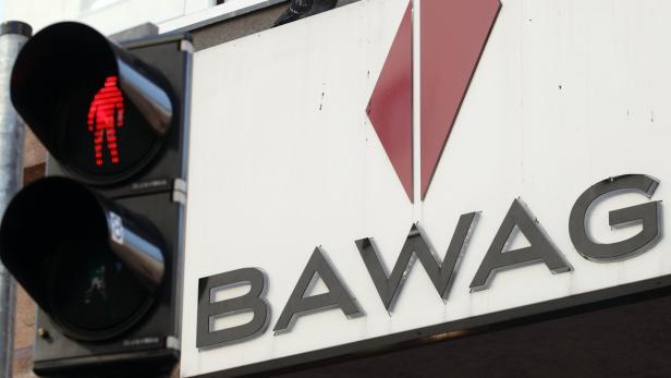 Eine rote Fußgängerampel leuchtet neben dem Schriftzug der BAWAG.