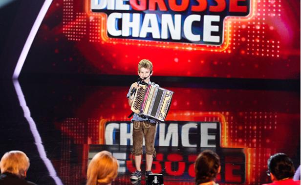 Johannes Raupl auf der Harmonika Ein Junge in Tracht spielt Akkordeon auf der Bühne von „Die große Chance“.