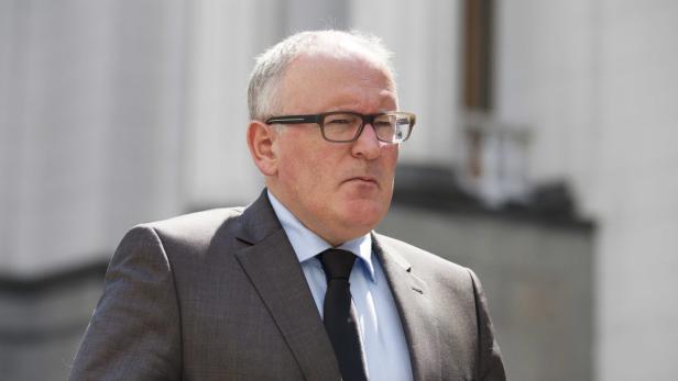 Ein Mann mit Brille, Anzug und Krawatte blickt in die Ferne.