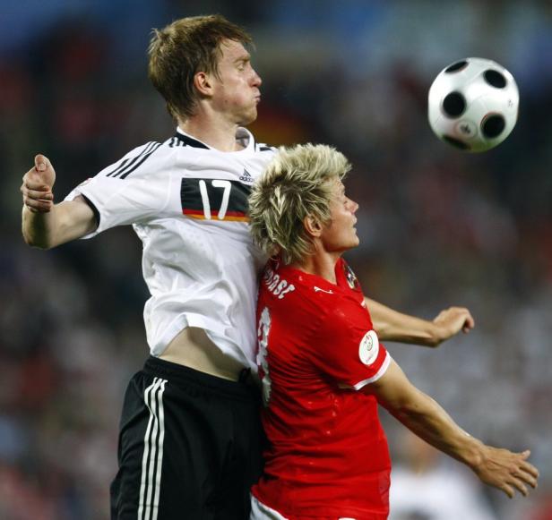 Zwei Fußballspieler kämpfen in der Luft um einen Ball.