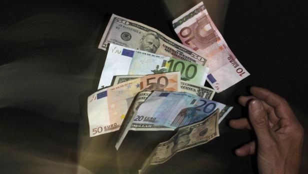 Euro and U.S. dollar banknotes are seen in this pi Verschiedene Euro- und Dollar-Banknoten liegen auf einem dunklen Untergrund.
