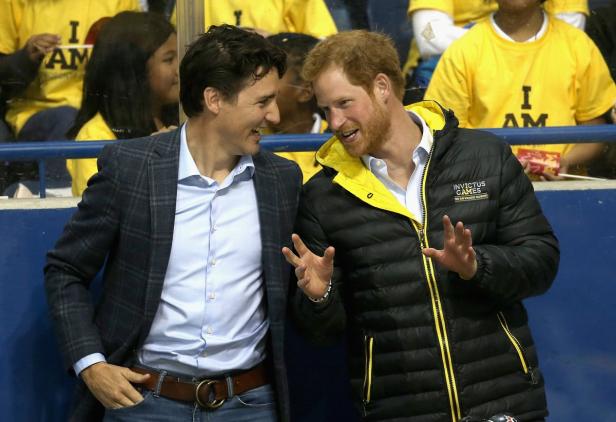 Justin Trudeau und Prinz Harry unterhalten sich lächelnd.