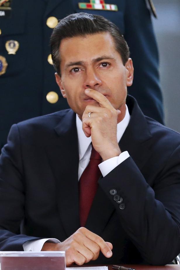 Ein Mann im Anzug denkt nach, die Finger am Mund.