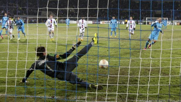 Ein Torwart hechtet nach dem Ball während eines Fußballspiels.