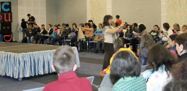 Eine Frau fotografiert das Publikum während einer Präsentation.