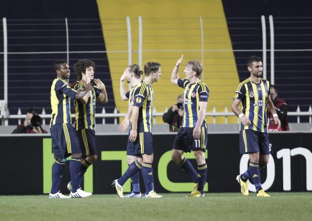 Mehrere Fußballspieler von Fenerbahçe feiern auf dem Spielfeld.