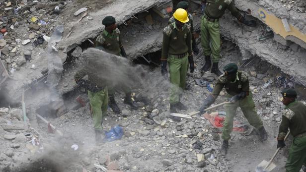 Mehrere Rettungskräfte suchen in den Trümmern eines eingestürzten Gebäudes nach Überlebenden.