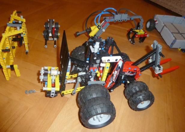 Ein Lego-Buggy mit verschiedenen Anbauteilen steht auf einem Holzboden.
