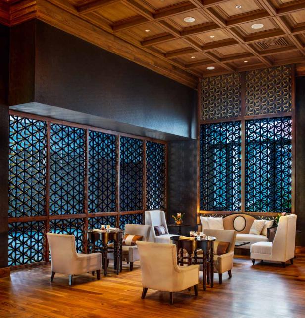 Ein elegant eingerichteter Loungebereich mit Holzboden und dekorativen Fensterschirmen.