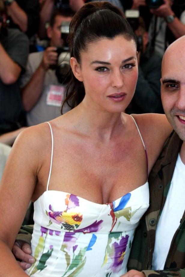 Monica Bellucci in einem geblümten Kleid posiert mit einem Mann.