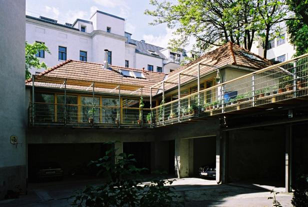 Ein Innenhof mit Garagen und einem überdachten Übergang zwischen zwei Gebäuden.