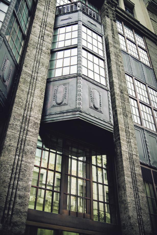 Detailaufnahme eines Gebäudes mit Erkerfenstern und dekorativen Elementen.