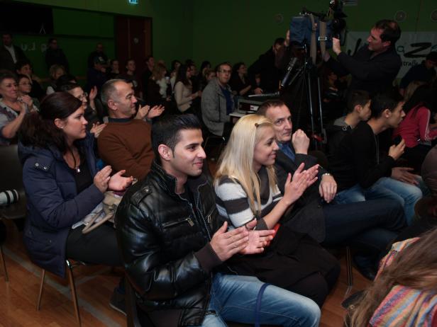 Ein Publikum applaudiert während einer Veranstaltung in einem Raum.