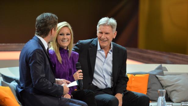 Harrison Ford und Helene Fischer sitzen auf einer Couch während einer TV-Show.
