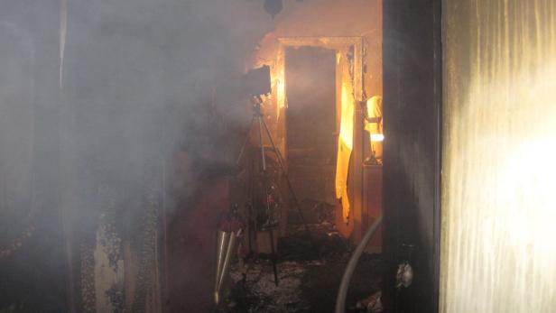 Ein Raum, der durch ein Feuer stark beschädigt wurde, ist voller Rauch.