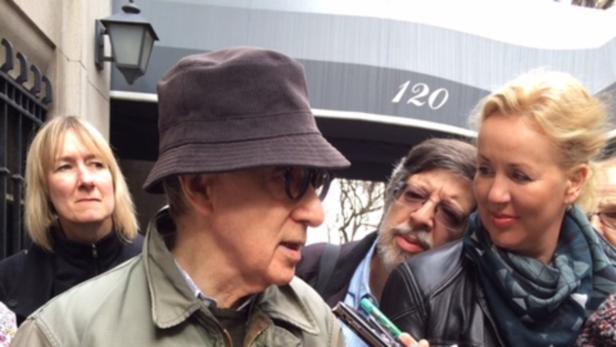 Woody Allen wird von Reportern vor einem Gebäude interviewt.
