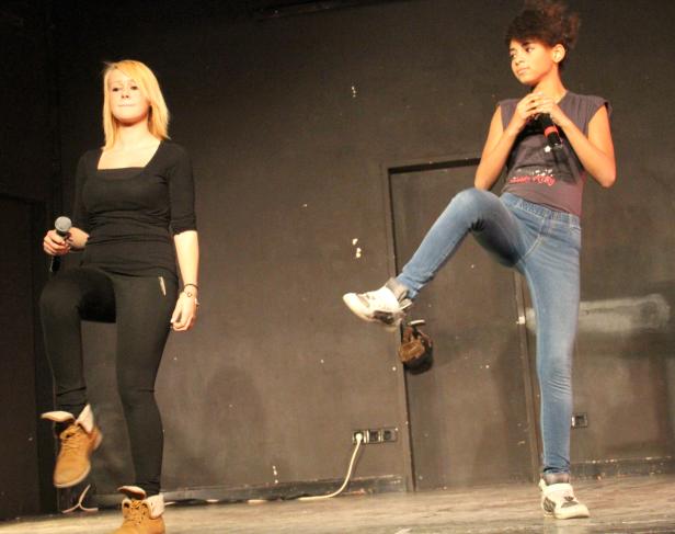 Zwei junge Frauen stehen auf einer Bühne und singen in Mikrofone.