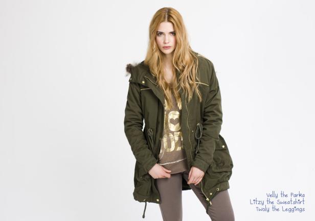 Eine Frau mit blonden Haaren trägt einen Parka und Leggings vor einem weißen Hintergrund.