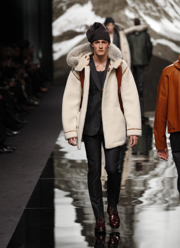 Ein Mann in Winterkleidung läuft auf einem Laufsteg.