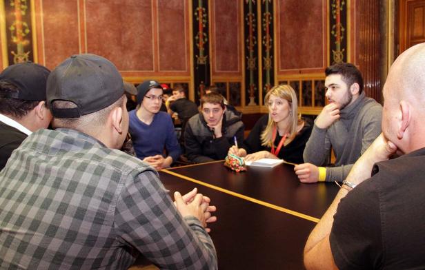 Eine Gruppe von Menschen sitzt an einem Tisch in einem verzierten Raum.
