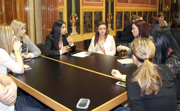 Mehrere Frauen sitzen an einem Tisch und diskutieren.