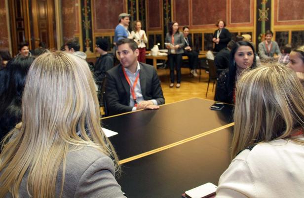 Menschen sitzen an einem Tisch in einem Konferenzraum.