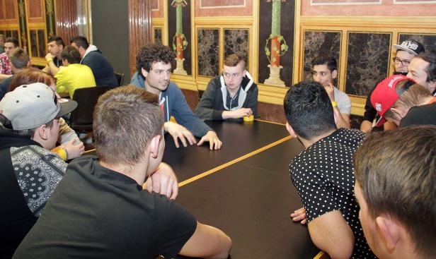 Eine Gruppe von Menschen sitzt an einem Tisch und scheint ein Spiel zu spielen.