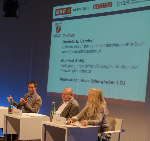 Daniela G. Camhy, Manfred Rühl und Alois Schörghuber auf einem Podium des ORF Kärnten.
