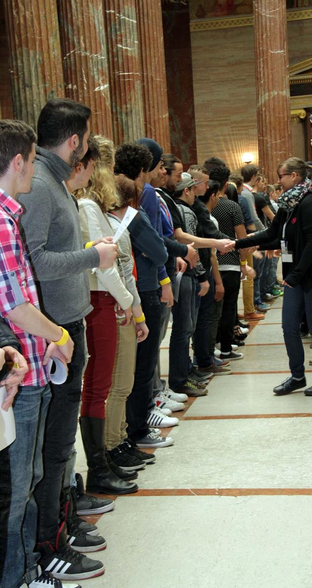 Eine lange Schlange von Menschen steht für eine Begrüßung bereit.