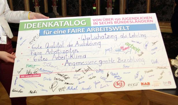 Ein Schild mit der Aufschrift „Ideenkatalog für eine faire Arbeitswelt“, unterschrieben von Jugendlichen.