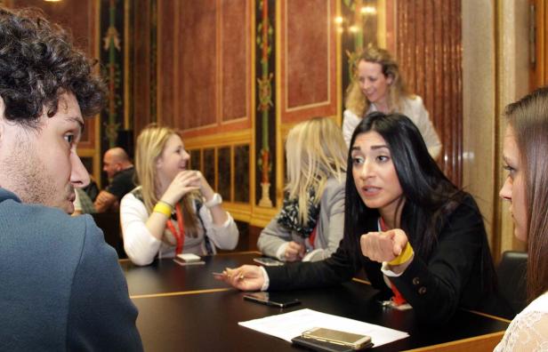 Eine Gruppe von Personen sitzt an einem Tisch und unterhält sich.