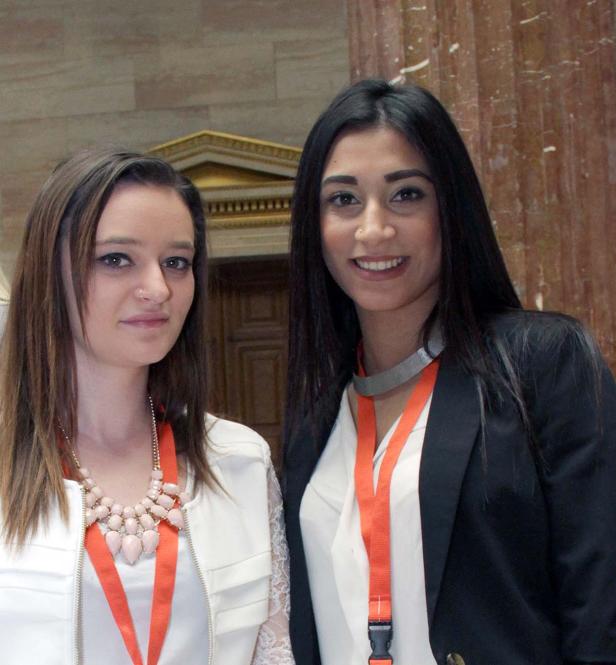 Zwei Frauen posieren mit Namensschildern in einem Gebäude.