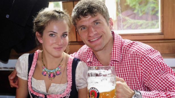 Thomas Müller mit seiner Frau in Tracht und einem Bierkrug in der Hand.