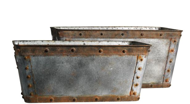 Zwei verzinkte, rechteckige Behälter mit Rostspuren stehen vor einem weißen Hintergrund.